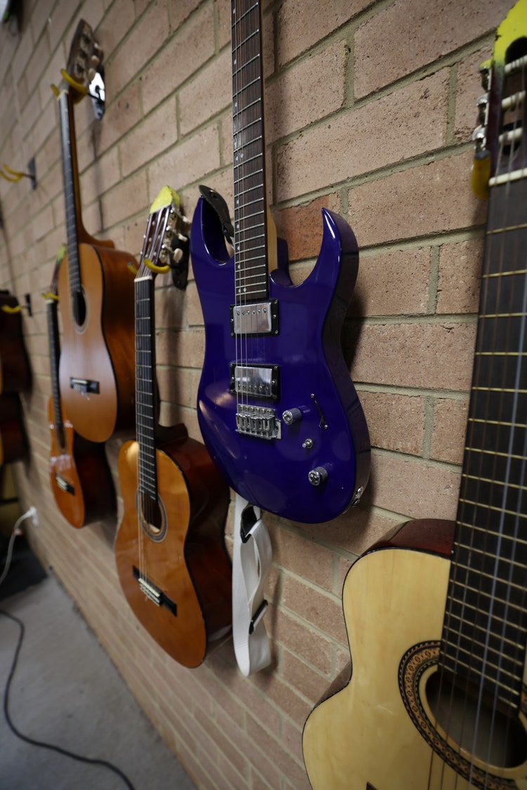 5 Guitars hanging on the wall.